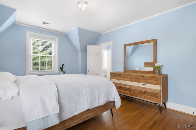 bedroom featuring ornamental molding, vaulted ceiling, and dark wood-type flooring