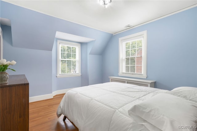 bedroom featuring light hardwood / wood-style flooring and lofted ceiling