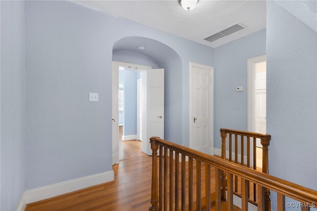 hallway featuring hardwood / wood-style floors and a textured ceiling