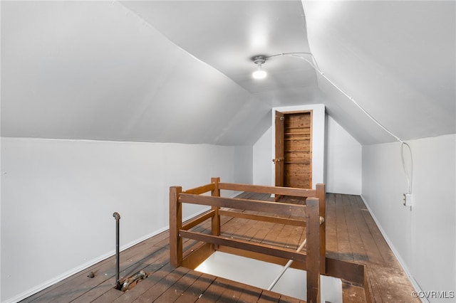 additional living space with wood-type flooring and vaulted ceiling