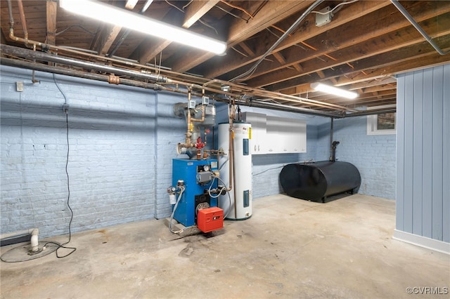 basement featuring electric water heater and brick wall