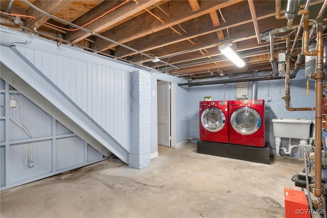 basement with washing machine and clothes dryer and sink