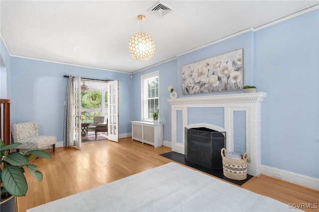 interior space with crown molding, light wood-type flooring, and a fireplace