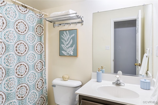 bathroom featuring toilet, vanity, and walk in shower