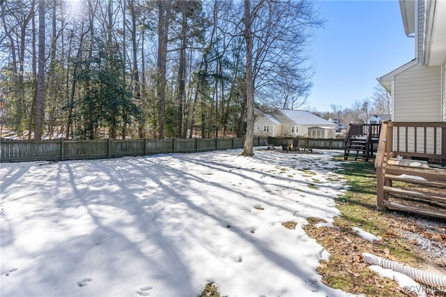 yard covered in snow with a wooden deck