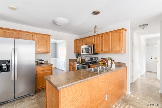 kitchen featuring kitchen peninsula, appliances with stainless steel finishes, and sink