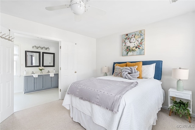 carpeted bedroom with ensuite bathroom and ceiling fan