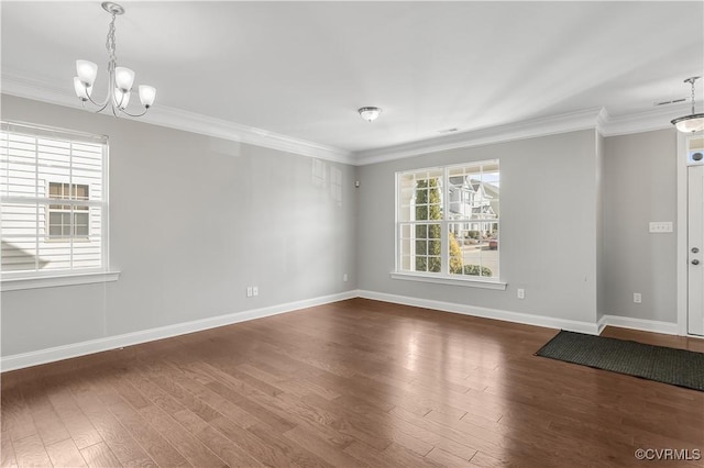 empty room featuring dark hardwood / wood-style flooring, a notable chandelier, and ornamental molding