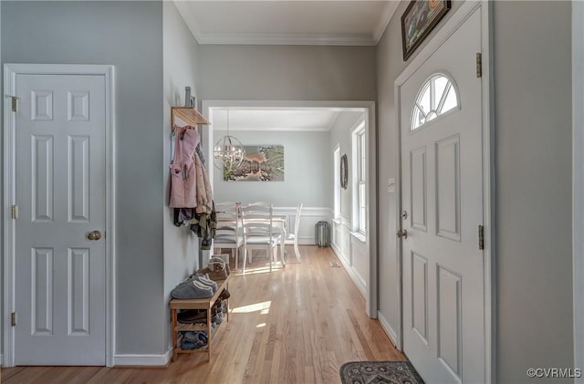 entryway featuring light hardwood / wood-style floors, crown molding, a chandelier, and radiator heating unit