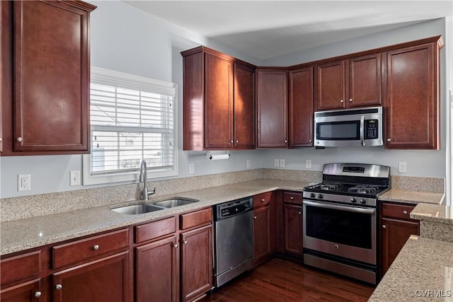 kitchen featuring light stone countertops, appliances with stainless steel finishes, dark hardwood / wood-style floors, and sink