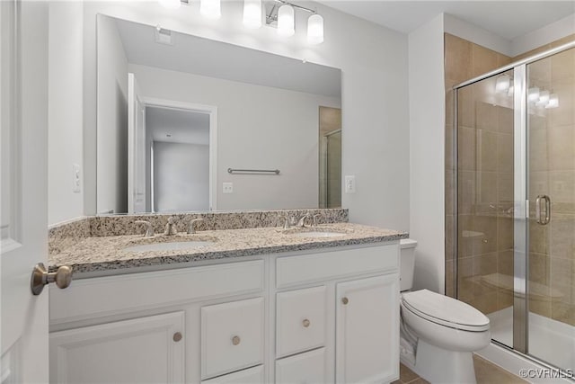 bathroom with toilet, an enclosed shower, and vanity