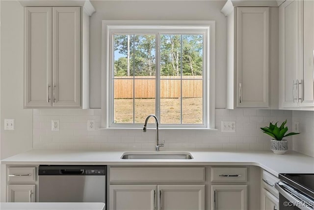 kitchen featuring dishwasher, white cabinets, tasteful backsplash, and sink