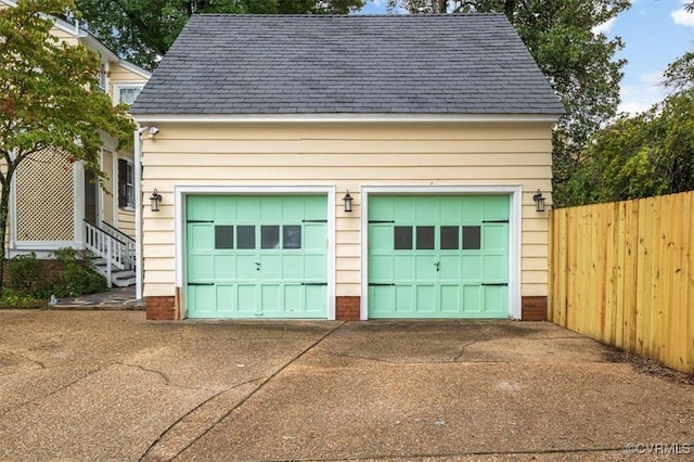 detached garage featuring fence