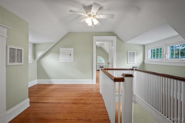 additional living space featuring baseboards, radiator heating unit, visible vents, and wood finished floors