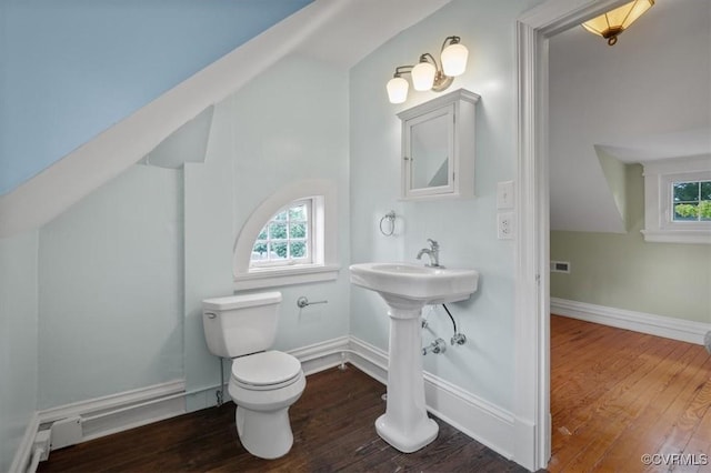 bathroom with toilet, hardwood / wood-style flooring, and baseboards