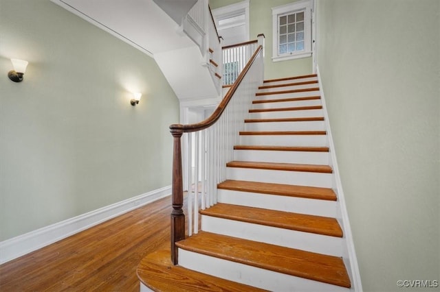 stairway with wood finished floors and baseboards