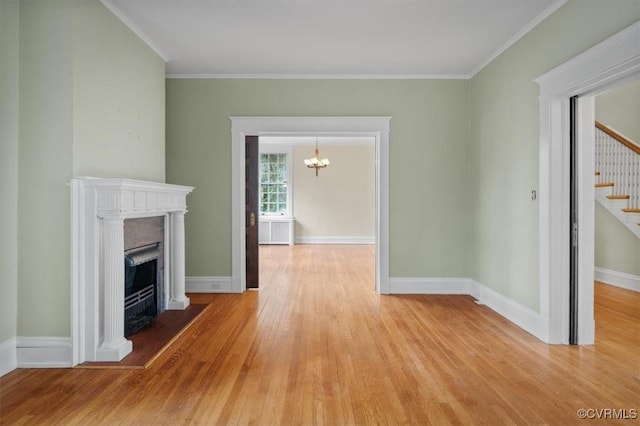 unfurnished living room with light wood finished floors, baseboards, a fireplace with flush hearth, stairway, and crown molding