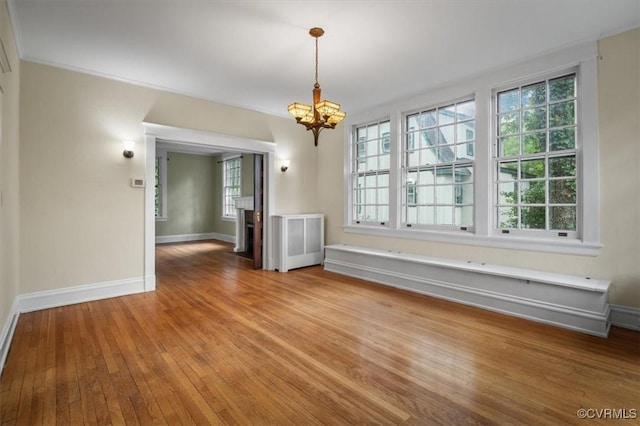 interior space featuring a chandelier, a healthy amount of sunlight, hardwood / wood-style flooring, and baseboards