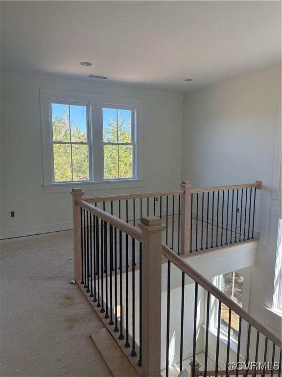 corridor featuring an upstairs landing, visible vents, and baseboards