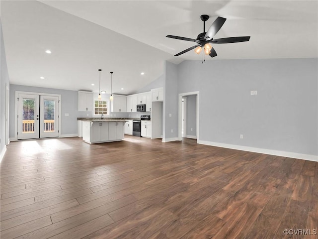 unfurnished living room with french doors, dark hardwood / wood-style flooring, ceiling fan, sink, and high vaulted ceiling