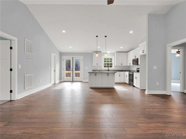 unfurnished living room featuring ceiling fan, dark wood-type flooring, and high vaulted ceiling