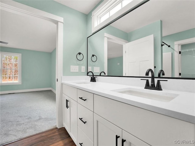 bathroom with hardwood / wood-style floors, vanity, and a healthy amount of sunlight