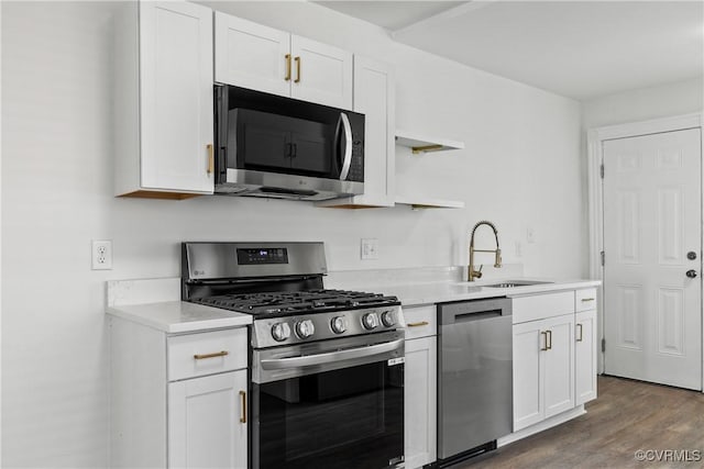 kitchen with stainless steel appliances, white cabinetry, and sink