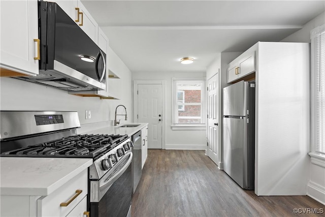 kitchen featuring white cabinets, stainless steel appliances, dark wood-type flooring, and sink