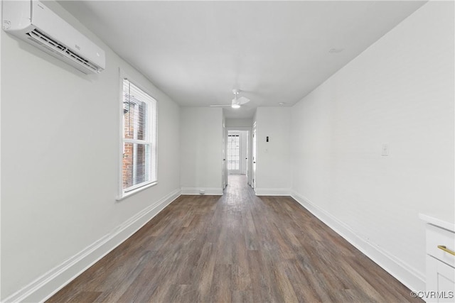 unfurnished room featuring a wall mounted AC, ceiling fan, and dark hardwood / wood-style flooring