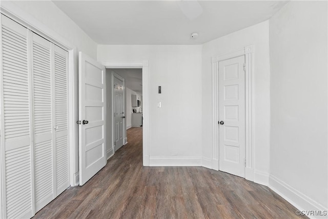 unfurnished bedroom featuring a closet and dark hardwood / wood-style floors