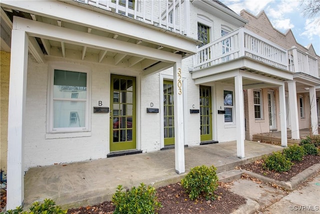 view of exterior entry with a balcony