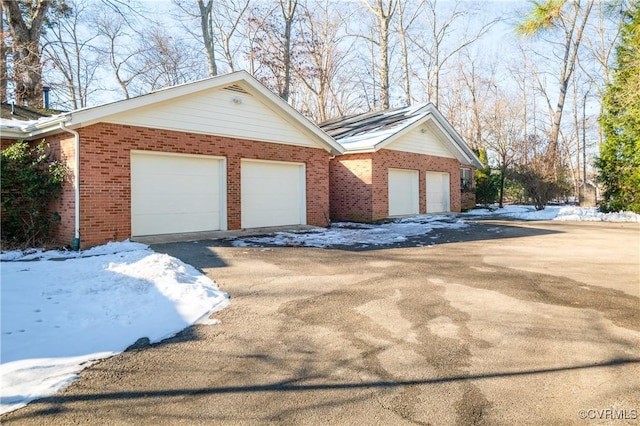 view of snow covered exterior featuring a garage