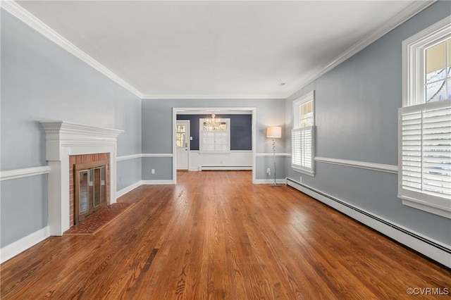 unfurnished living room with a baseboard heating unit, ornamental molding, a fireplace, and wood-type flooring