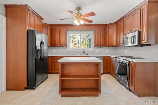 kitchen featuring ceiling fan, sink, stainless steel appliances, and a kitchen island