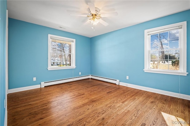 spare room featuring baseboard heating, hardwood / wood-style flooring, and ceiling fan