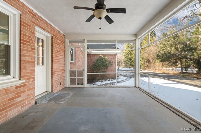 unfurnished sunroom with ceiling fan