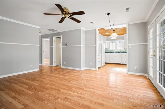 unfurnished living room with light wood-type flooring, ceiling fan, and crown molding