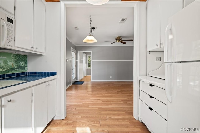 kitchen featuring white cabinetry, tasteful backsplash, decorative light fixtures, white appliances, and ornamental molding