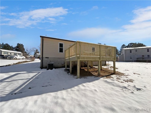 snow covered property featuring cooling unit and a deck