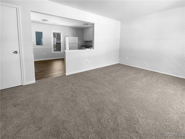 unfurnished living room with electric panel and dark carpet