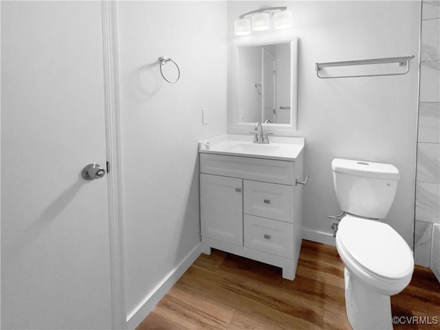 bathroom with vanity, wood-type flooring, and toilet