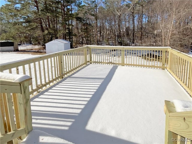 snow covered deck with a storage shed