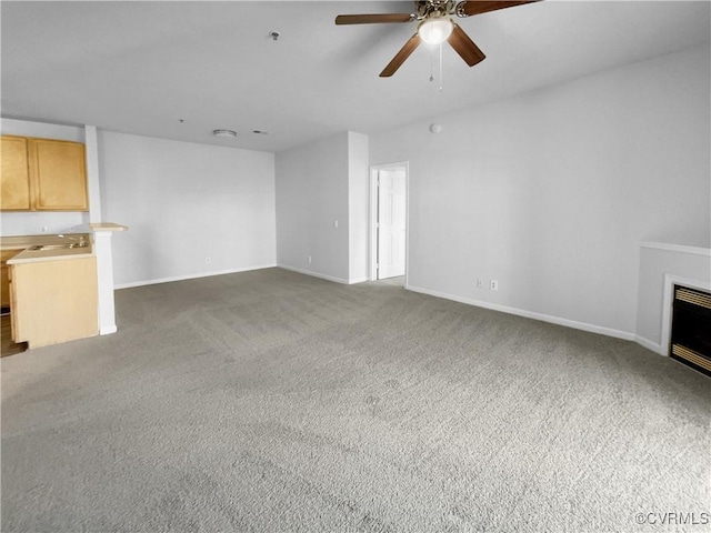 unfurnished living room with dark colored carpet and ceiling fan