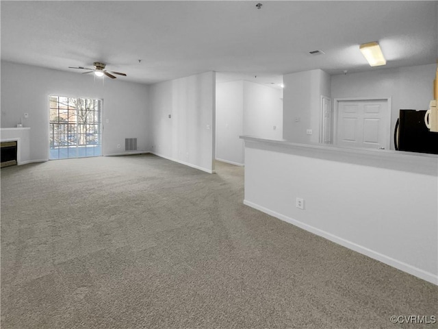 unfurnished living room featuring carpet and ceiling fan