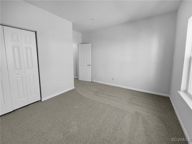 unfurnished bedroom featuring carpet and a closet