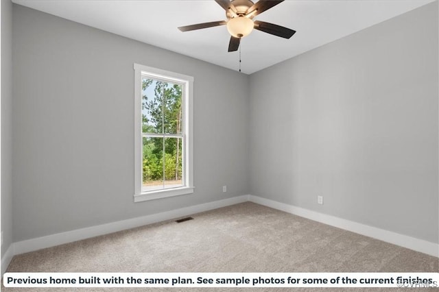 carpeted spare room featuring baseboards, visible vents, and a ceiling fan