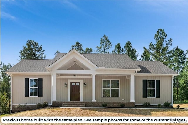 view of front of home with a shingled roof, brick siding, and board and batten siding