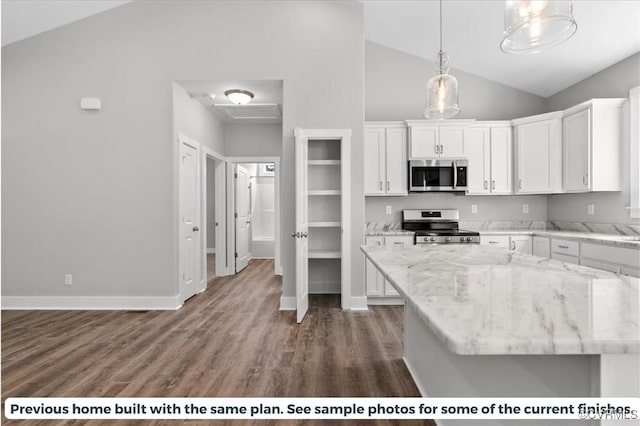 kitchen featuring baseboards, wood finished floors, decorative light fixtures, stainless steel appliances, and white cabinetry