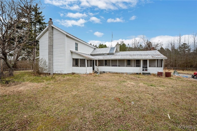 back of property featuring a lawn and a sunroom