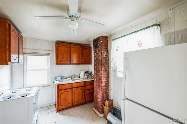 kitchen with ceiling fan, sink, white appliances, and decorative columns